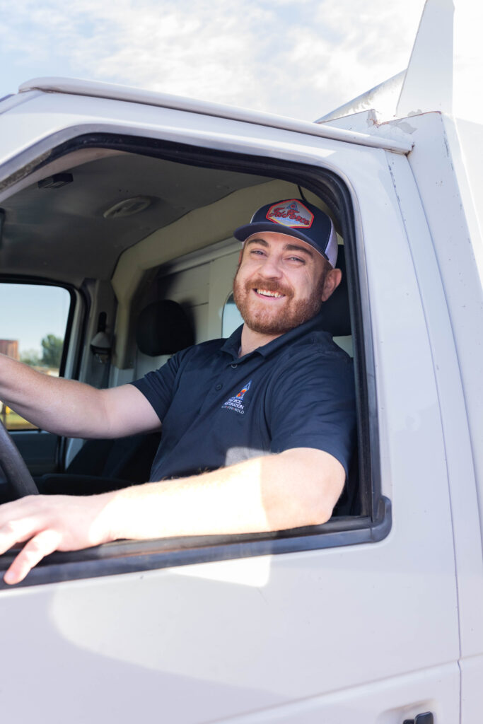 Friendly restoration contractor technician in a service truck, supporting emergency water removal as part of a water mitigation company.