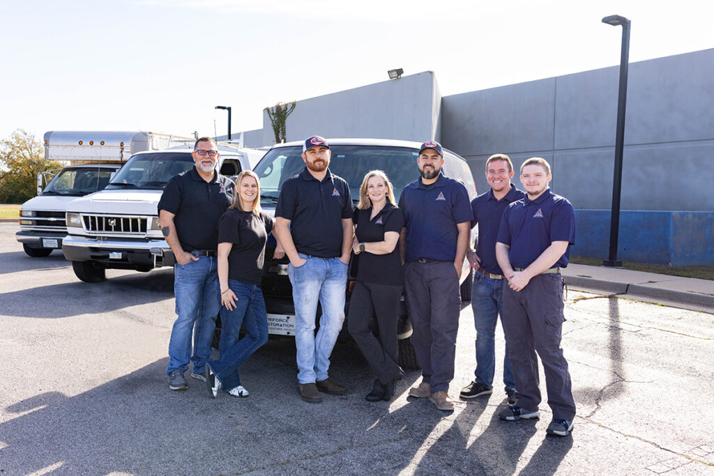 TriForce Restoration team standing in front of service vehicles, representing a trusted Oklahoma restoration contractor ready to respond to emergency calls.