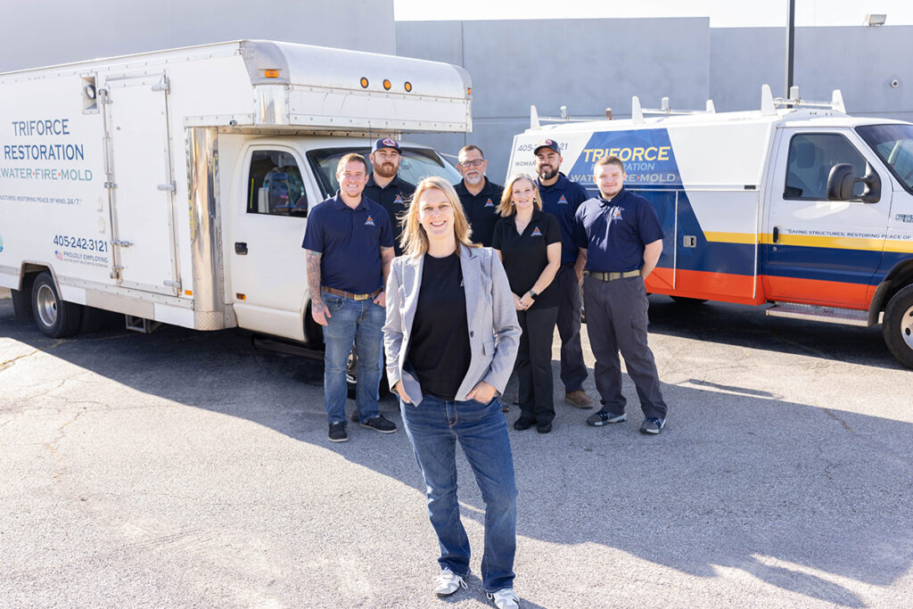TriForce Restoration team standing with service vehicles, representing a woman-owned restoration contractor providing water removal as a trusted water mitigation company serving Oklahoma.